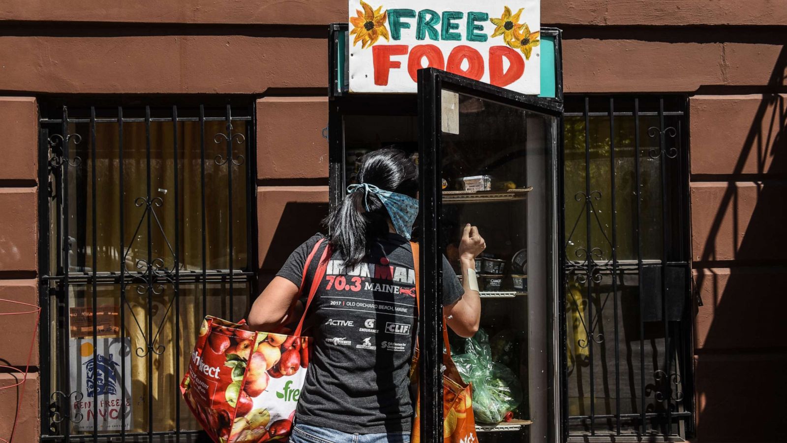 PHOTO: A person wearing a protective mask browses a free food refrigerator on May 5, 2020, in the Bedford-Stuyvesant neighborhood in the Brooklyn borough of New York.