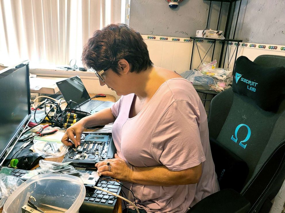 PHOTO: Darla Purce, of Houston, Texas, works to refurbish a laptop for a student doing distance learning.
