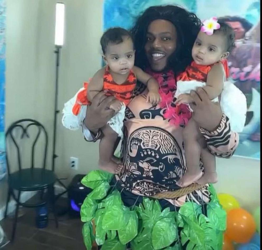 PHOTO: James Finley, in costume as Maui from the movie "Moana," holds his twin daughters AmieLynn and JamieLynn at their first birthday party.