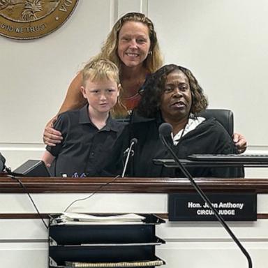 PHOTO: Jackie Coombe, center back, a former teacher, adopted her former student, Jaden, left, in June 2026.