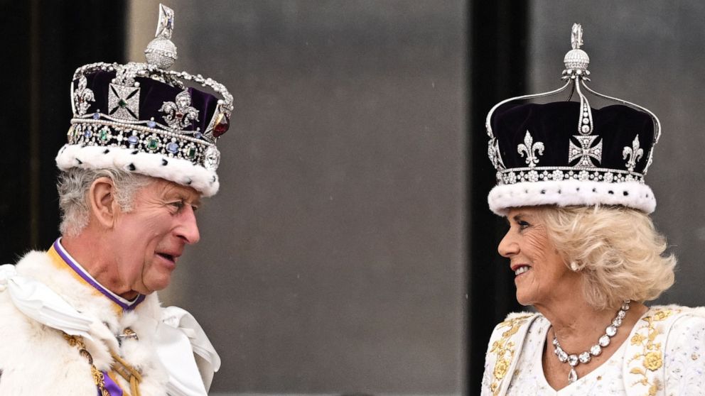 PHOTO: Britain's King Charles III wearing the Imperial state Crown, and Britain's Queen Camilla wearing a modified version of Queen Mary's Crown chat on the Buckingham Palace balcony on May 6, 2023, after their coronations.