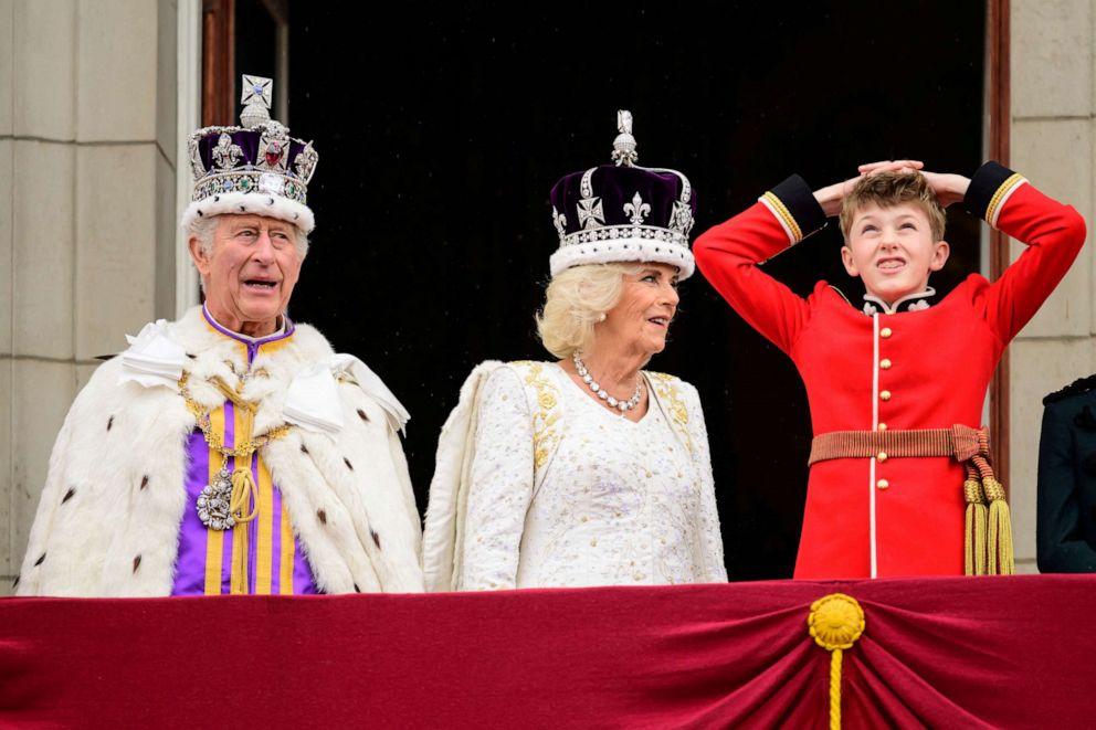 PHOTO: King Charles III and Queen Camilla look out from the balcony next to Page of Honor, Freddy Parker Bowles at Buckingham Palace during the Coronation of King Charles III and Queen Camilla on May 6, 2023 in London.