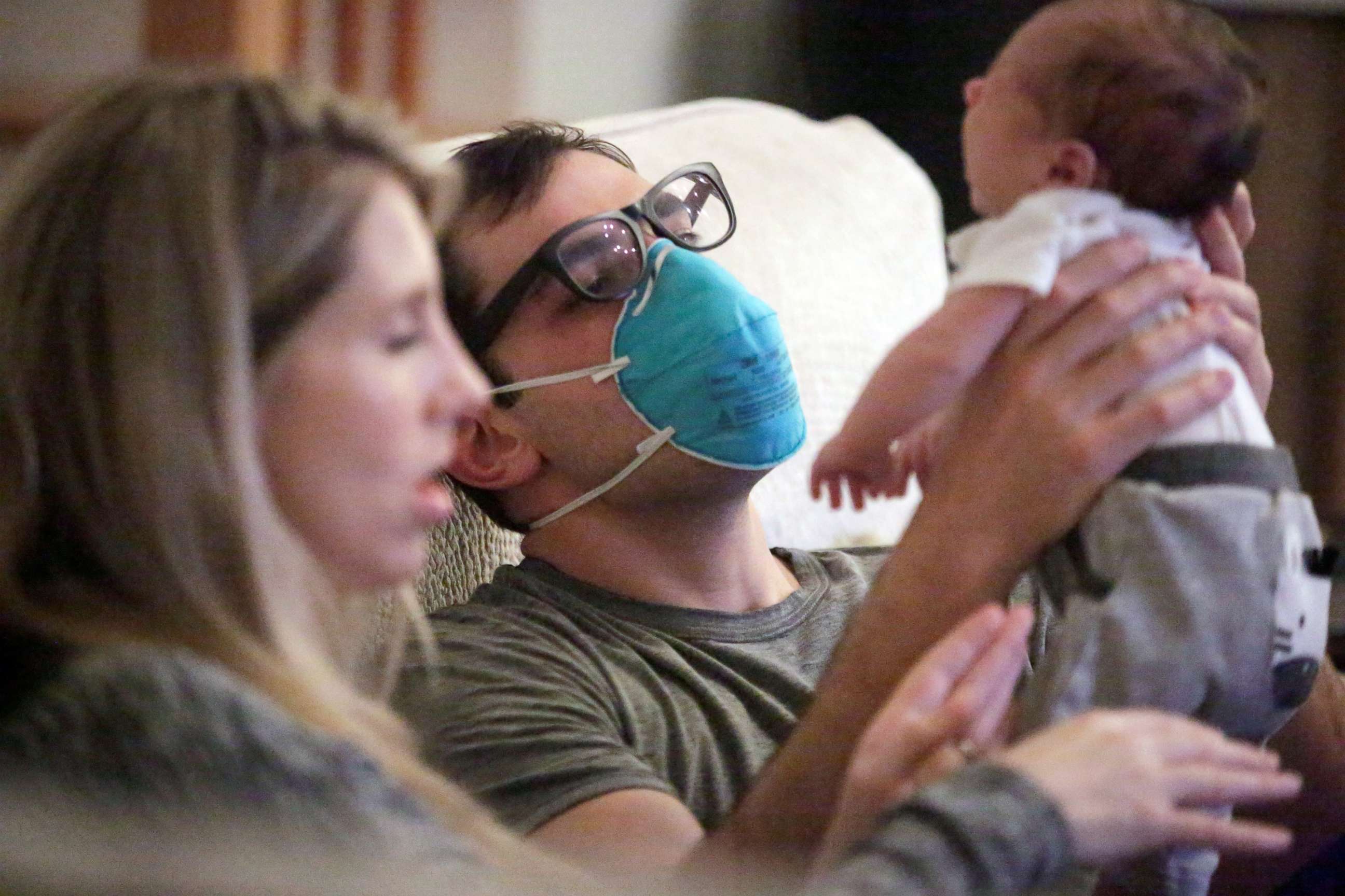 PHOTO: Emergency medicine physician Thomas Krajewski wears a mask as he holds his baby Cal with his wife Genevieve after finishing his shift amid an outbreak of coronavirus disease in New Orleans, March 27, 2020