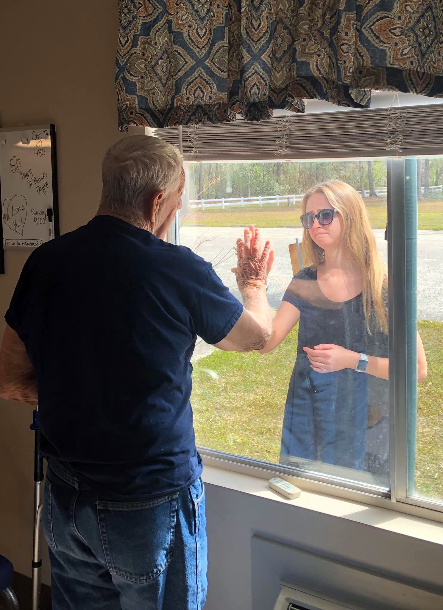 PHOTO: Carly Boyd announces her engagement to her grandfather Shelton Mahala, 87, through his nursing home window in Lake Waccamaw, N.C., in a photo shared on Facebook March 16, 2020.