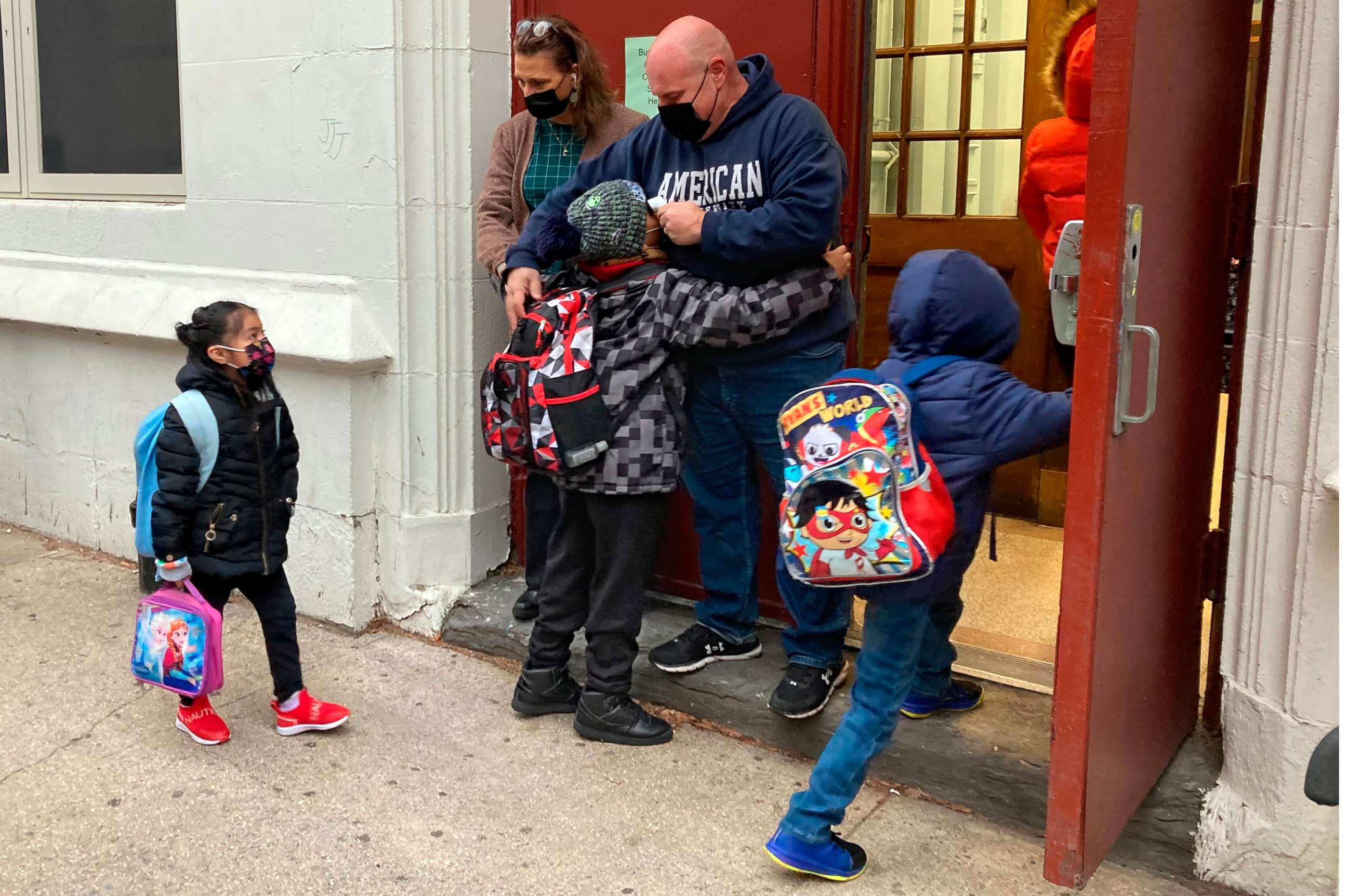 PHOTO: John Marro, the dean of students at P.S. 347, The American Sign Language and English Lower School, in New York, takes students' temperatures as they arrive on the first day after the holiday break, Monday, Jan. 3, 2022.
