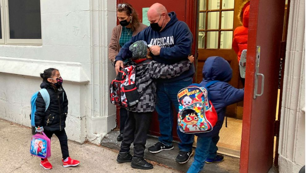 PHOTO: John Marro, the dean of students at P.S. 347, The American Sign Language and English Lower School, in New York, takes students' temperatures as they arrive on the first day after the holiday break, Monday, Jan. 3, 2022.