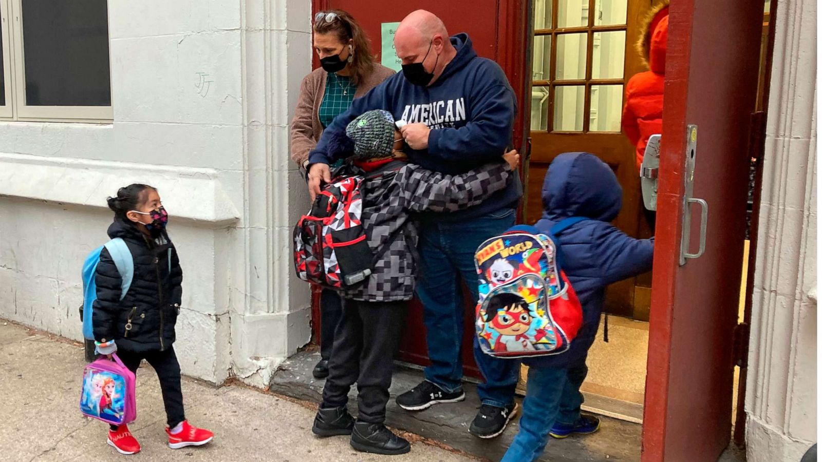 PHOTO: John Marro, the dean of students at P.S. 347, The American Sign Language and English Lower School, in New York, takes students' temperatures as they arrive on the first day after the holiday break, Monday, Jan. 3, 2022.