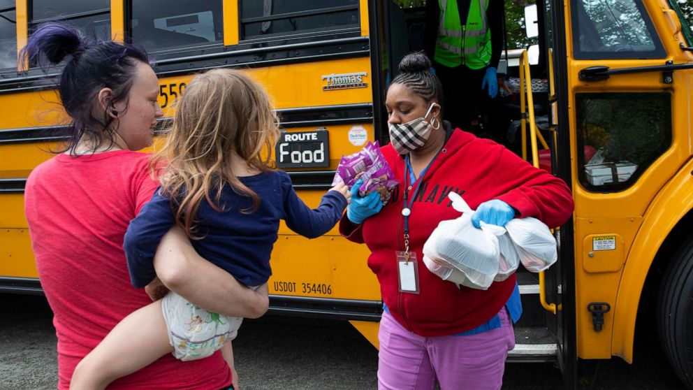 PHOTO: Bus driver Treva White and nutritionist Shaunte Fields deliver meals to children and their families on May 6, 2020, in Seattle.