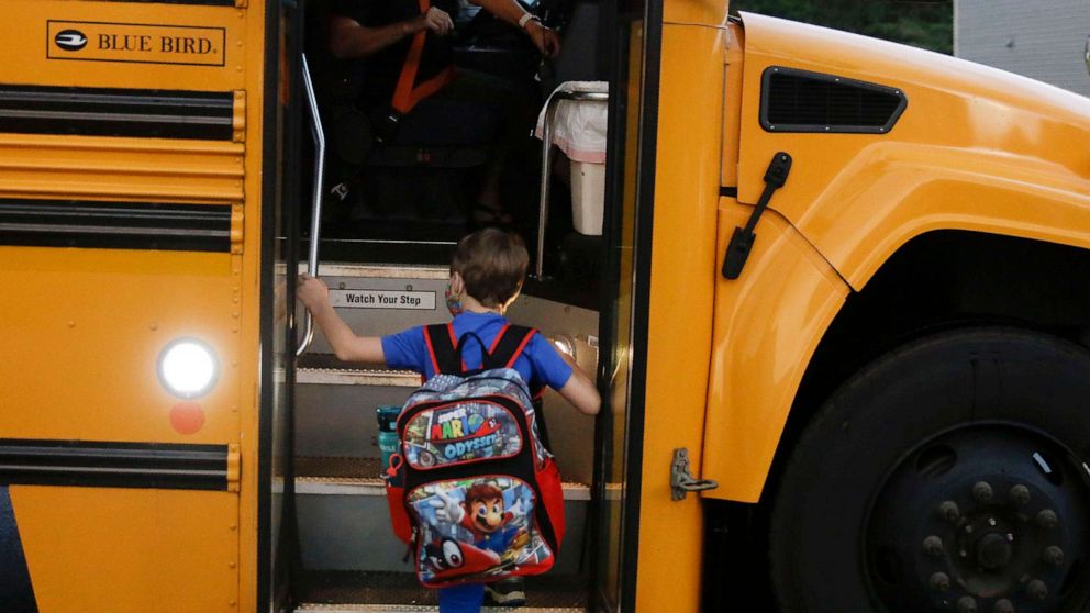 PHOTO: A student climbs the stairs of a school bus before the first day of school in Dallas, Aug. 3, 2020.