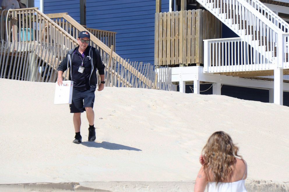 PHOTO: FedEx driver Joe Engel delivers the wedding ring to Savannah Kulenic during her wedding ceremony to Dylan Perkins on a North Carolina beach, April 10, 2020.