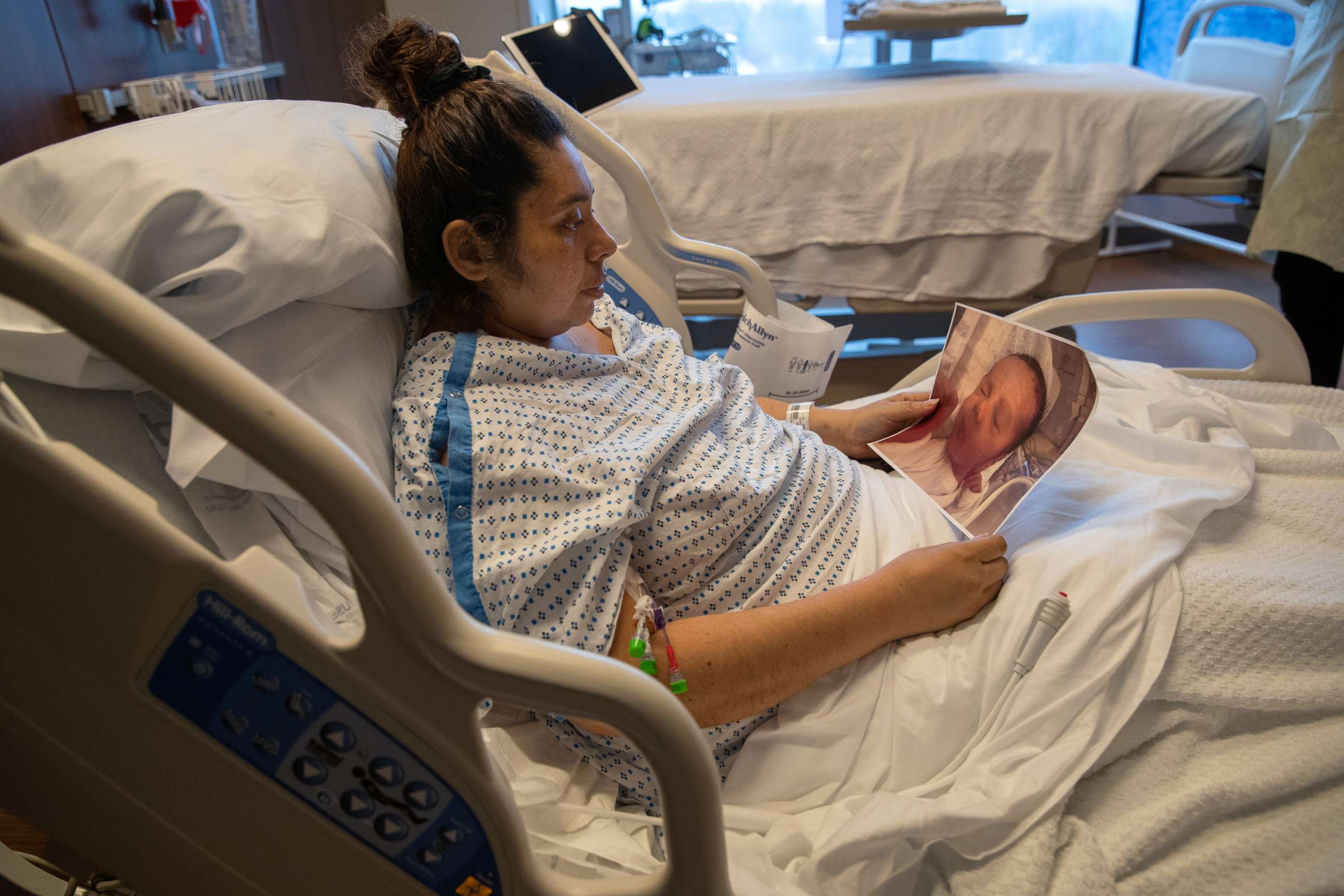 PHOTO: COVID-19 patient Zully looks at a photo of her newborn baby Neysel while in a Stamford Hospital ICU on April 24, 2020, in Stamford, Conn.