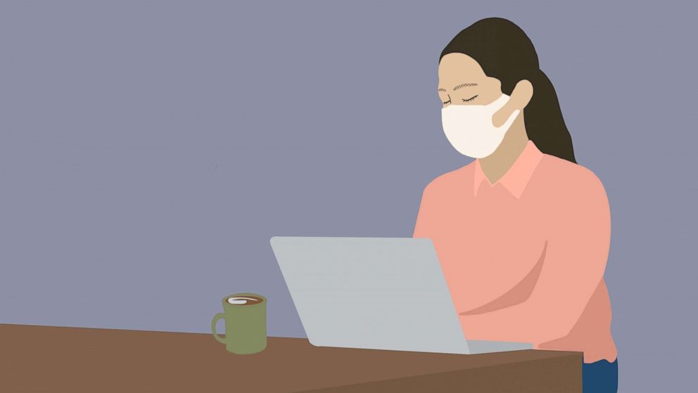 PHOTO: An illustration shows a person wearing a face mask while using a laptop.