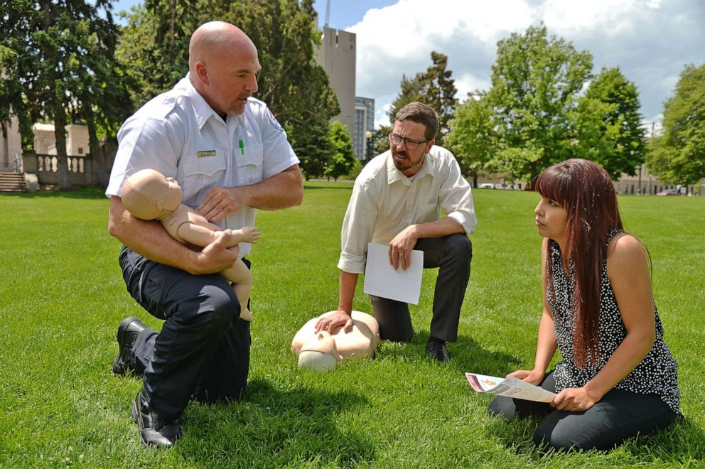 PHOTO: A paramedic uses a dummy to demonstrate how to perform CPR to an infant during a National EMS week event at Civic Center Park in Denver, May 23, 2018.