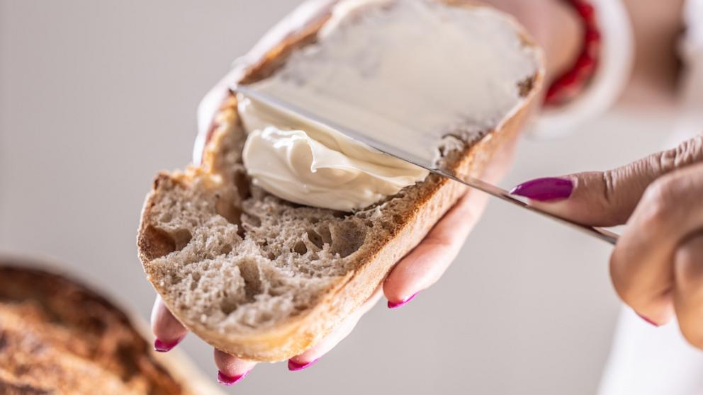 PHOTO: In this undated stock photo, a woman is seen spreading cream cheese on a slice of bread. 