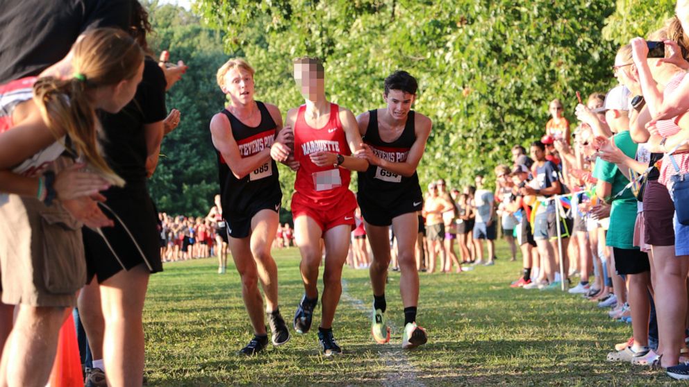 Cross-country runners stop their race to help opponent across finish line -  ABC News