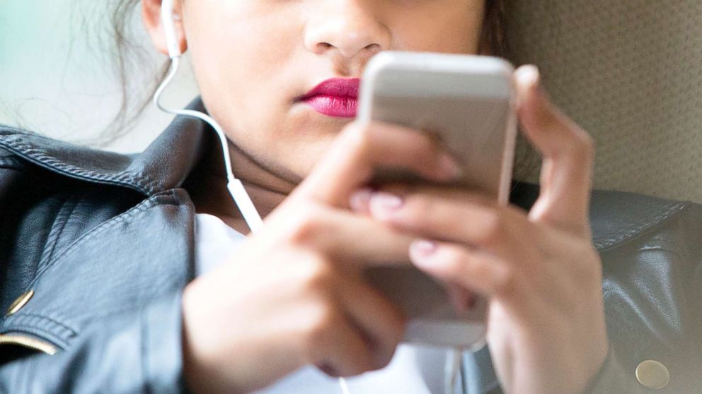 A teenage girl looks at her phone in this undated stock photo.