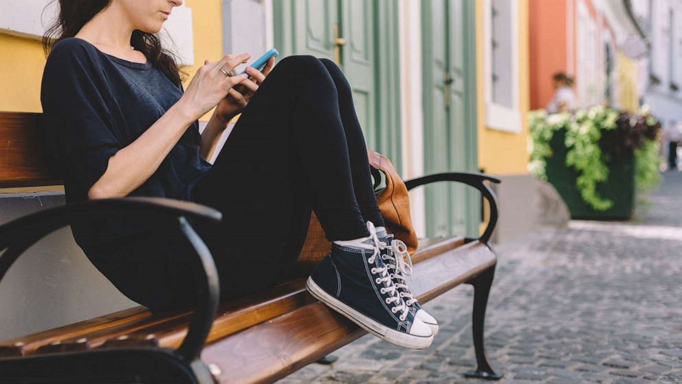 A young woman uses a smartphone in this undated stock photo.