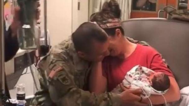 PHOTO: Skyler Cooper, a member of the Kansas Army National Guard, surprises his wife, Cydney Cooper of Topeka, Kansas and their newborn twins, Emma and Kyla Cooper.