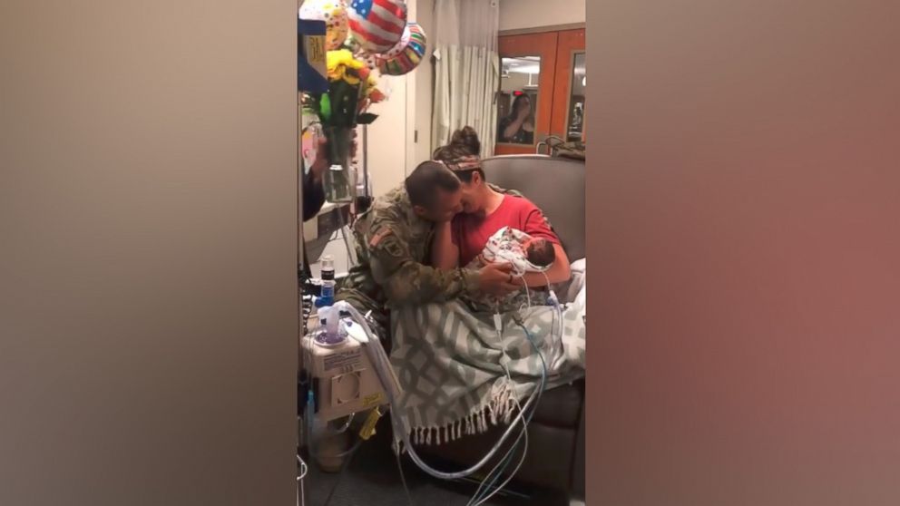 PHOTO: Skyler Cooper, a member of the Kansas Army National Guard, surprises his wife, Cydney Cooper of Topeka, Kansas and their newborn twins, Emma and Kyla Cooper.