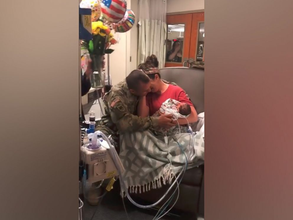 PHOTO: Skyler Cooper, a member of the Kansas Army National Guard, surprises his wife, Cydney Cooper of Topeka, Kansas and their newborn twins, Emma and Kyla Cooper.