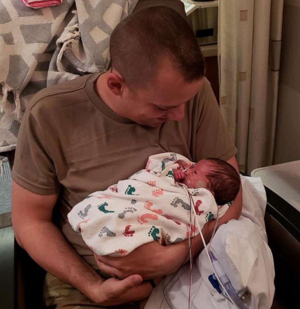 PHOTO: Skyler Cooper, a member of the Kansas Army National Guard, holds his newborn daughter, Kyla Cooper, on Feb. 4. 