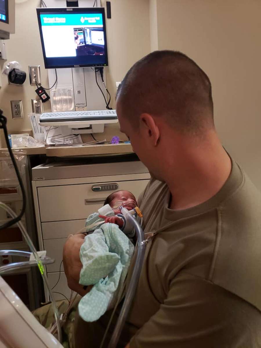 PHOTO: Skyler Cooper, a member of the Kansas Army National Guard, holds his newborn daughter, Emma Cooper, on Feb. 4.