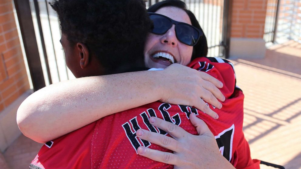 PHOTO: Dana Gendreau hugs the Hughes football player as they get off the bus before there game on Oct. 6, 2019.