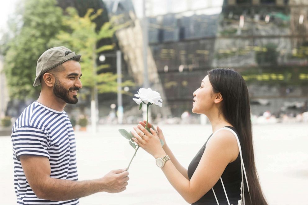 PHOTO: A man gives a flower to his girlfriend.