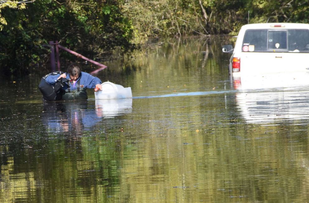 PHOTO: Sharon Logan wades through chest-deep water to retrieve belongings from her flooded house in the aftermath of Hurricane Delta in Alexandria, La., Oct. 15, 2020.