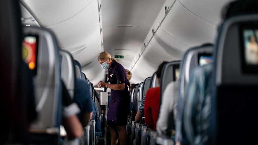 PHOTO: Flight attendants hand out refreshments to a packed Delta Airlines flight traveling from Ronald Regan National Airport to MinneapolisSaint Paul International Airport, May 21, 2021.