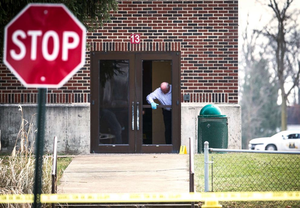 PHOTO: Investigators examine a a door at Dennis Intermediate School where a shooter allegedly broke the glass to enter the building in Richmond, Ind., Dec. 13, 2018.