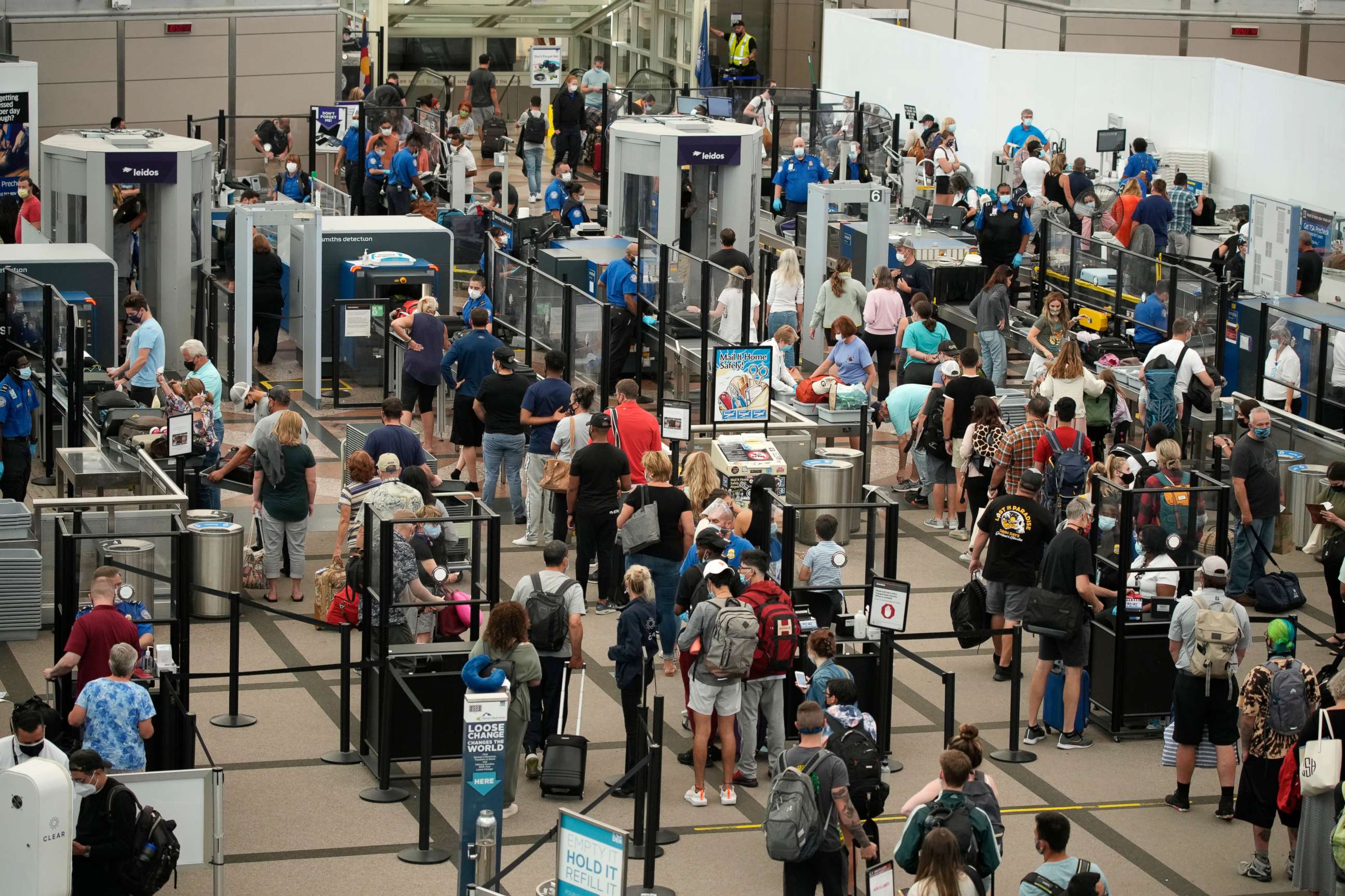 PHOTO: Travelers wear face coverings while in line at the security checkpoint in the main terminal of Denver International Airport, Aug. 24, 2021, in Denver.