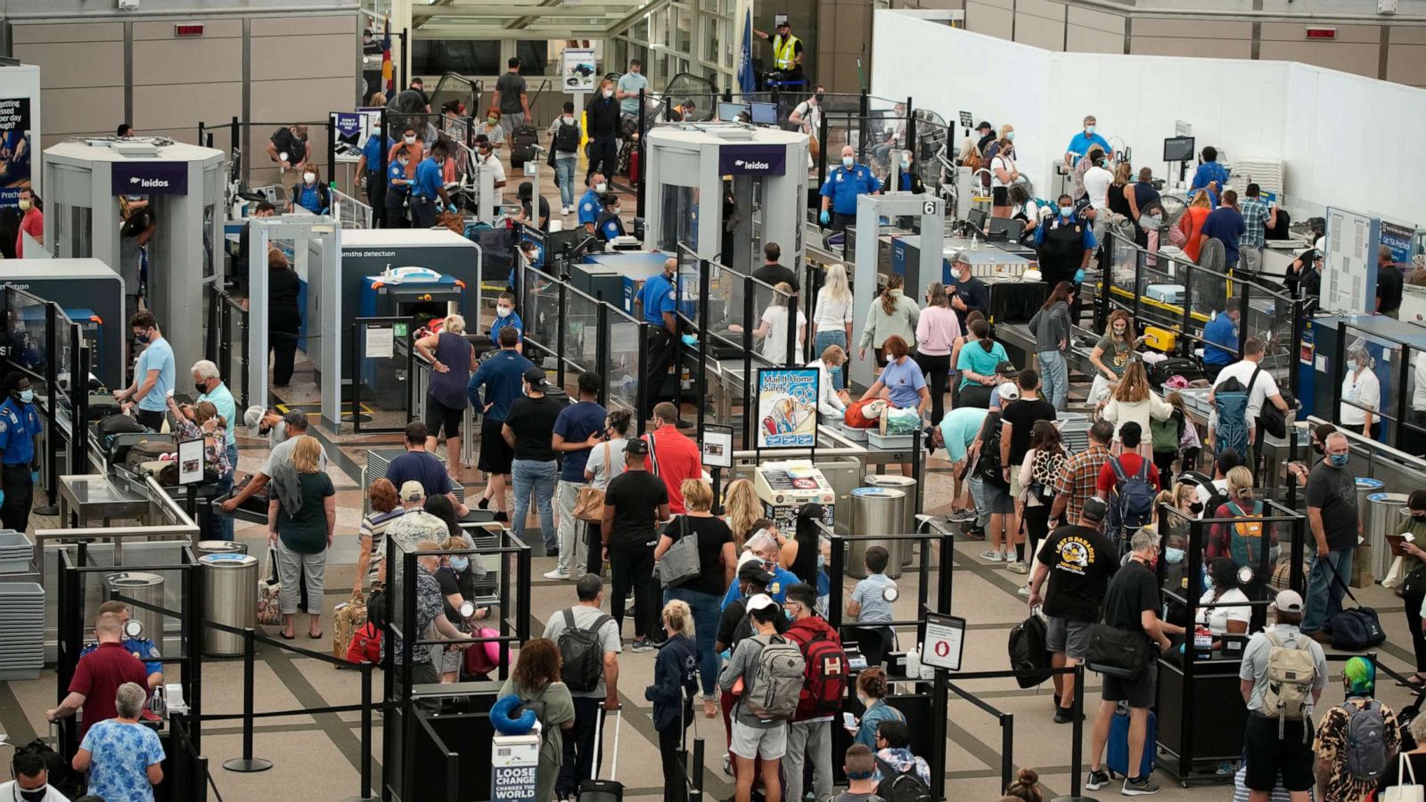 PHOTO: Travelers wear face coverings while in line at the security checkpoint in the main terminal of Denver International Airport, Aug. 24, 2021, in Denver.