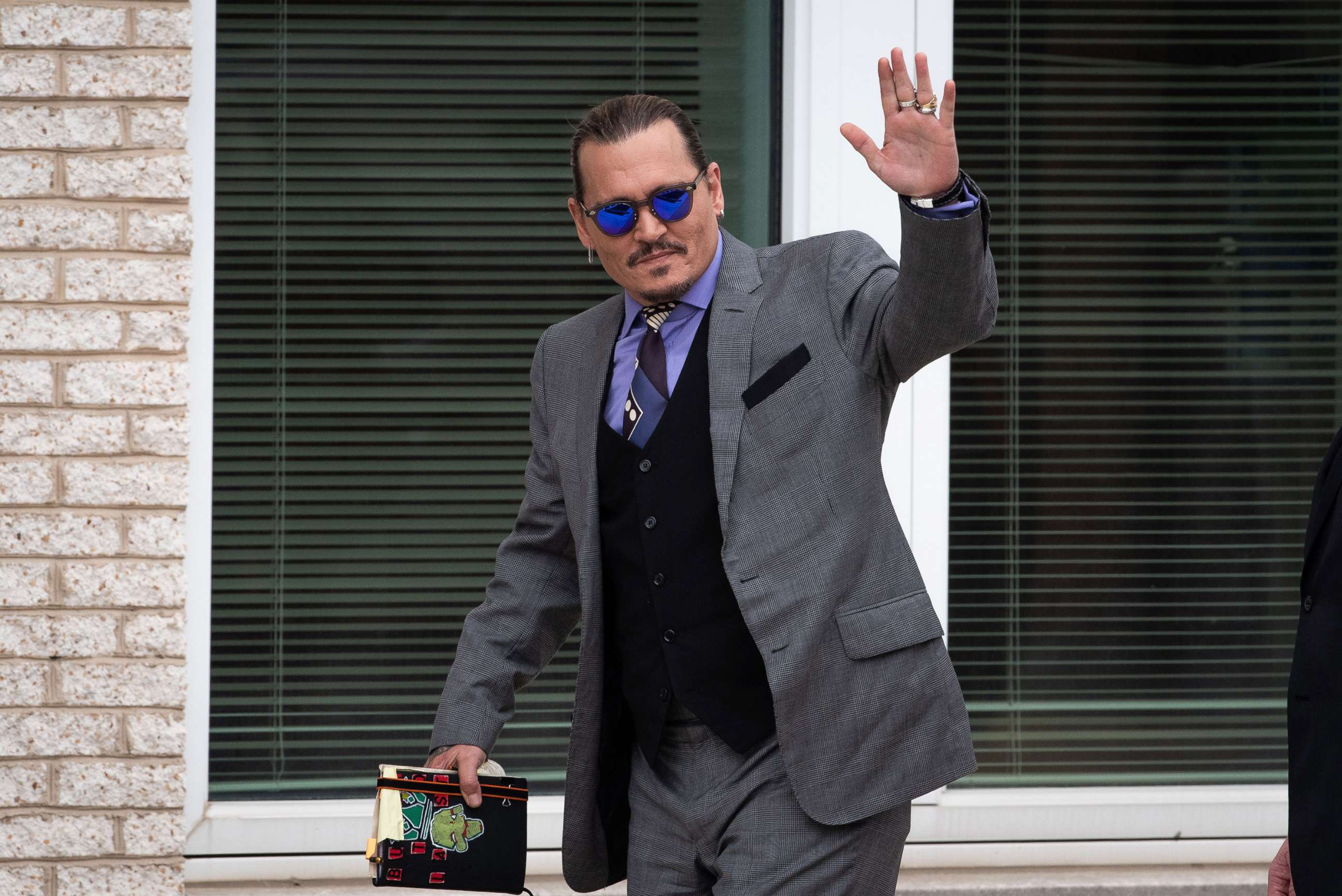 PHOTO: Johnny Depp waves to his fans during an afternoon recess outside court during the Johnny Depp and Amber Heard civil trial at Fairfax County Circuit Court, May 4, 2022, in Fairfax, Va.
