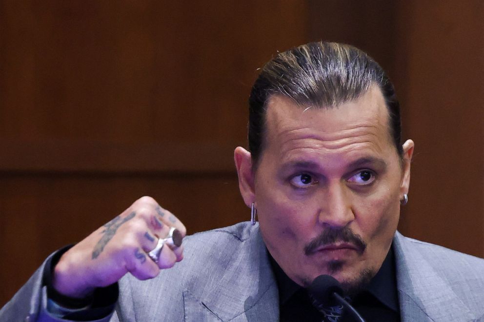 PHOTO: Actor Johnny Depp demonstrates how he claims his ex-wife Amber Heard punched him as he testifies during his defamation trial against Heard, at the Fairfax County Circuit Courthouse in Fairfax, Va., April 20, 2022. 