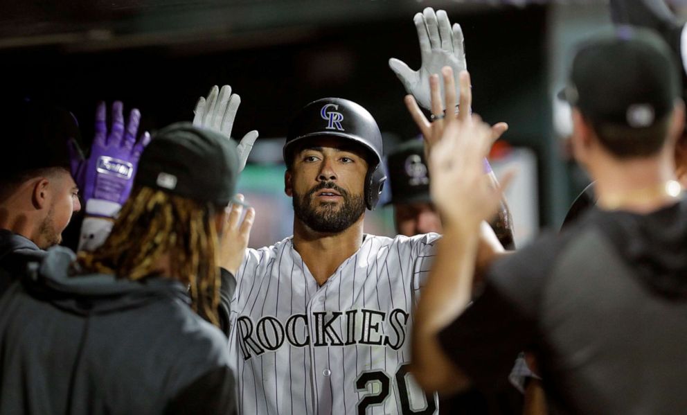 PHOTO: Ian Desmond of the Colorado Rockies is congratulated in the dugout after his home run against the Pittsburgh Pirates in the eighth inning at Coors Field, Aug. 30, 2019, in Denver.