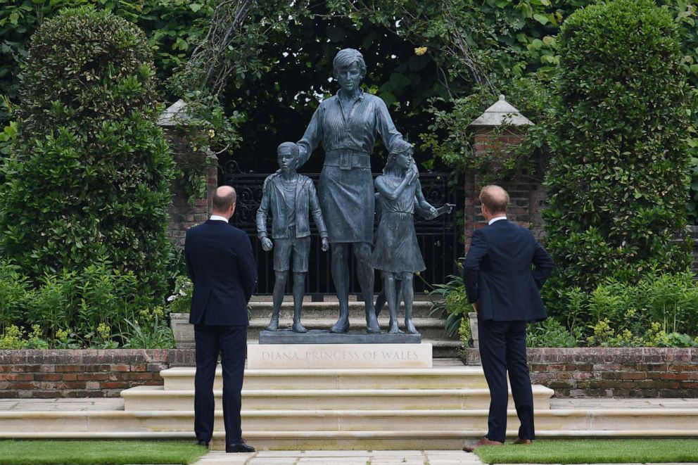PHOTO: Prince William and Prince Harry look at a statue they commissioned for their mother Diana in Kensington Palace's Sunken Garden on what would have been her 60th birthday, July 1, 2021, in London .