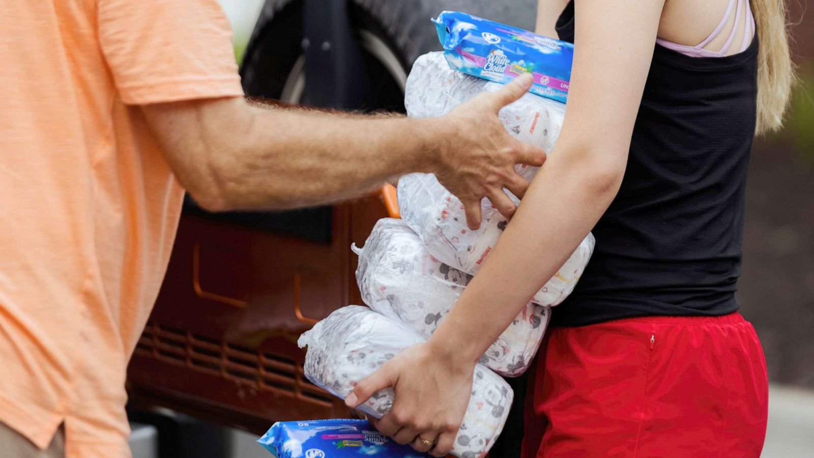 PHOTO: A HappyBottoms volunteers deliver diapers to a vehicle at a food pantry drive-thru event in Liberty, Miss., July 7, 2021.