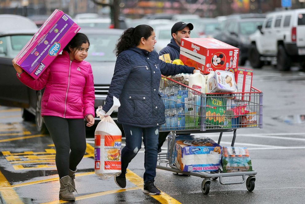 PHOTO: Shoppers stock up on staples including diapers, toilet paper, bottled water, and canned goods at the Costco in Everett, Mass., amid coronavirus concerns on March 13, 2020. 