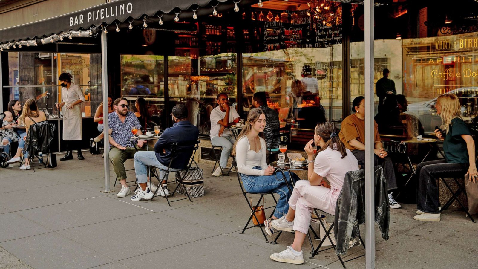 PHOTO: Customers sit in the outdoor dining area of a restaurant in the West Village neighborhood of New York, April 28, 2021.