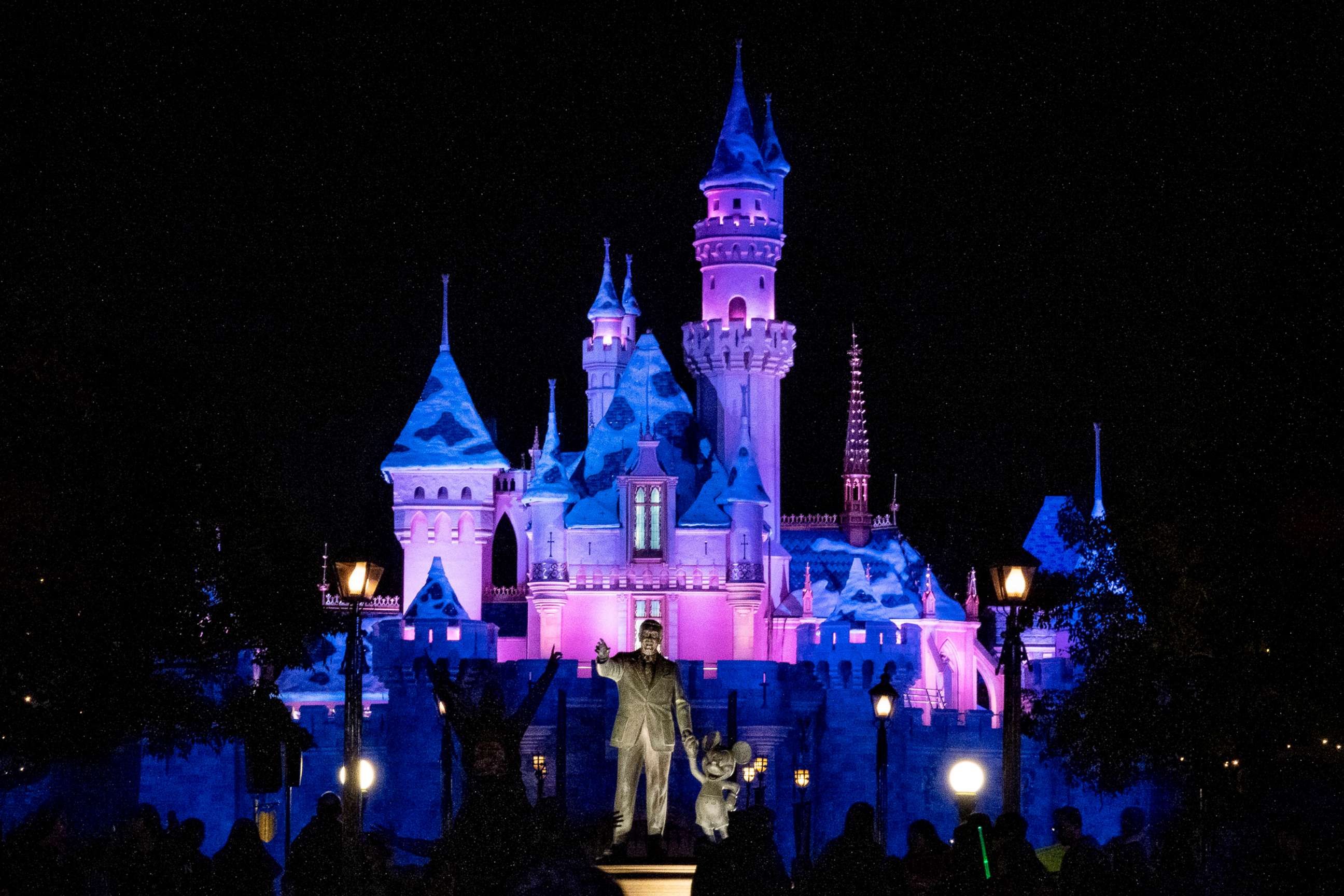 PHOTO: A general view of the Walt Disney and Mickey Mouse statue in front of the Sleeping Beauty Castle lit up at night at Disneyland Park on Jan. 13, 2020, in Anaheim, Calif.