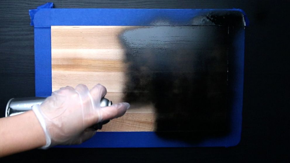 PHOTO: Chalkboard spray paint being applied to wooden cutting board.
