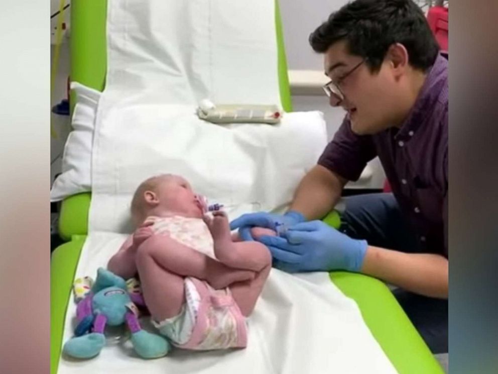 PHOTO: An image made from video shows Dr. Ryan Coetzee sanging Nat King Coles Unforgettable to soothe a 10-month-old baby, Gracey, during blood tests at Raigmore Hospital in Scotland.