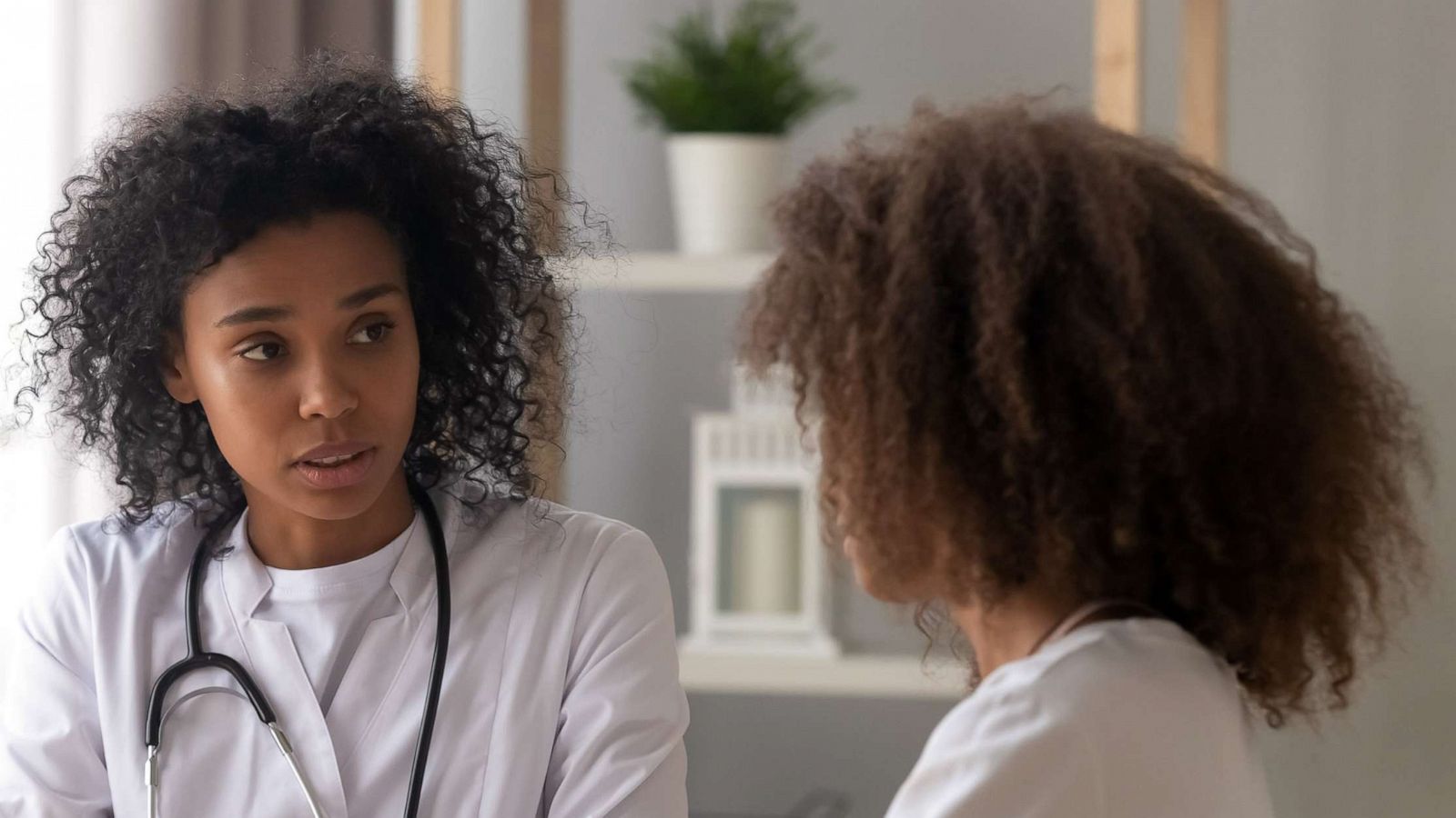 PHOTO: A doctor talks to her patient and prepares to make notes on a chart in this stock photo.