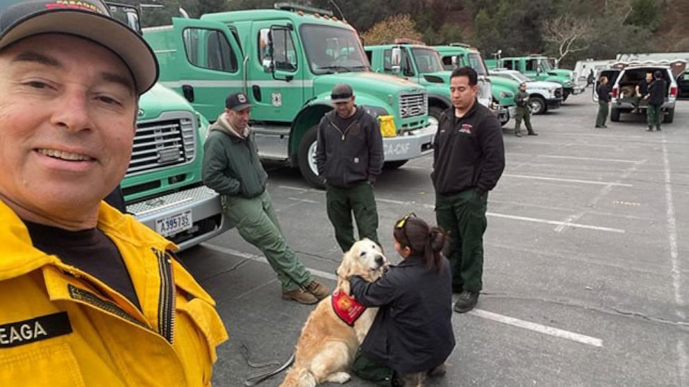 PHOTO: Victor Laveaga takes a selfie as Jack, the Golden Retriever, helps a group of first responders during the Los Angeles fires. 