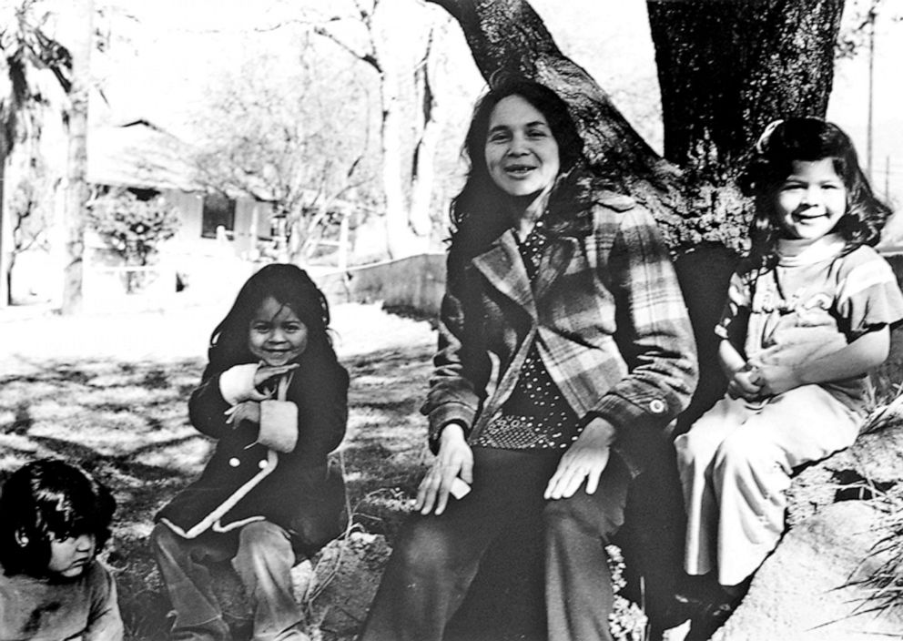 PHOTO: Labor activist and cofounder of the United Farm Workers of America (UFW) Dolores Huerta and her daughters sit outdoors on a tree, Keene, California, mid 1970s.