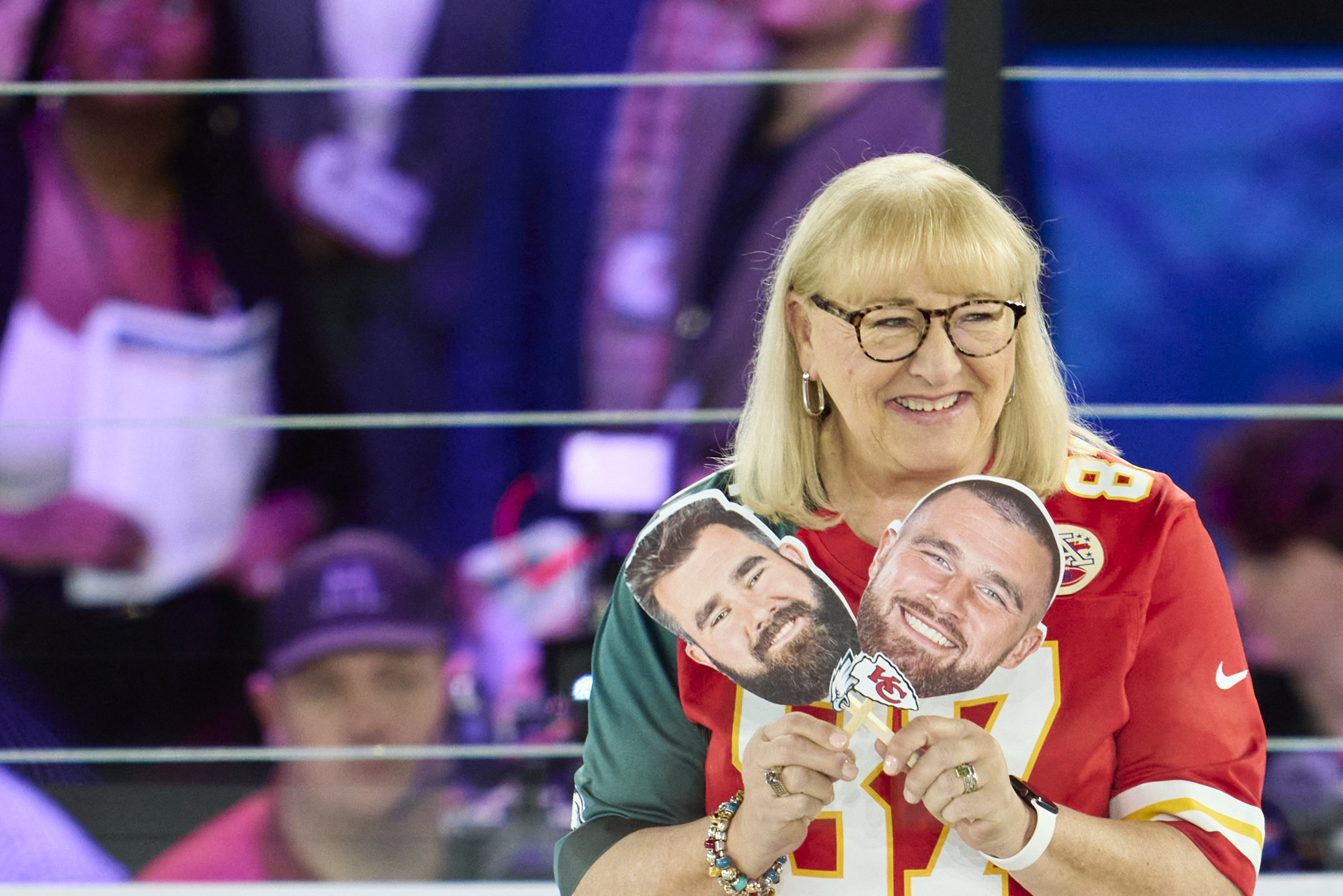 PHOTO: Donna Kelce holds up photos of her sons, Jason Kelce #62 of the Philadelphia Eagles and Travis Kelce #87 of the Kansas City Chiefs at Footprint Center, Feb. 6, 2023, in Phoenix.