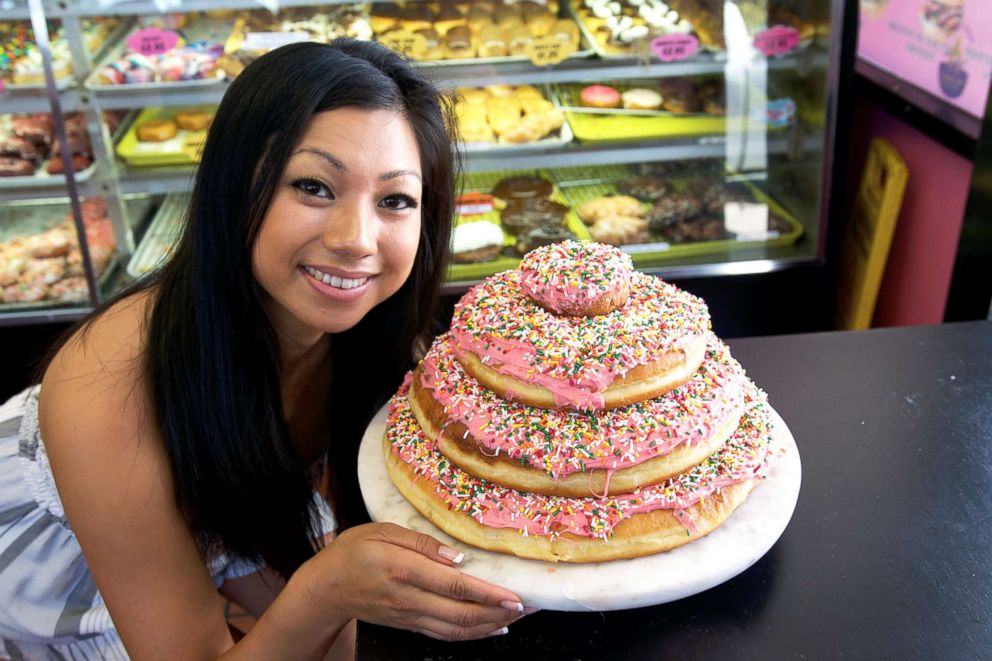 PHOTO: DK's Donuts & Bakery owner Mayly Tao smiles as she poses with one of her famous donut towers