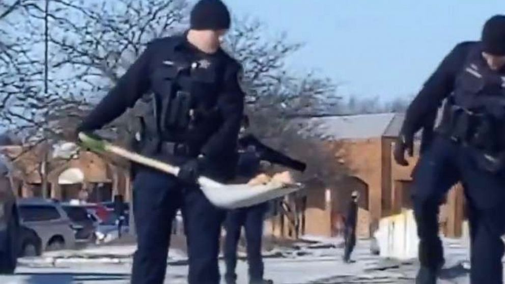 PHOTO: Officers from the Wheaton Police Department shovel doughnuts from Naperville Road in Illinois.