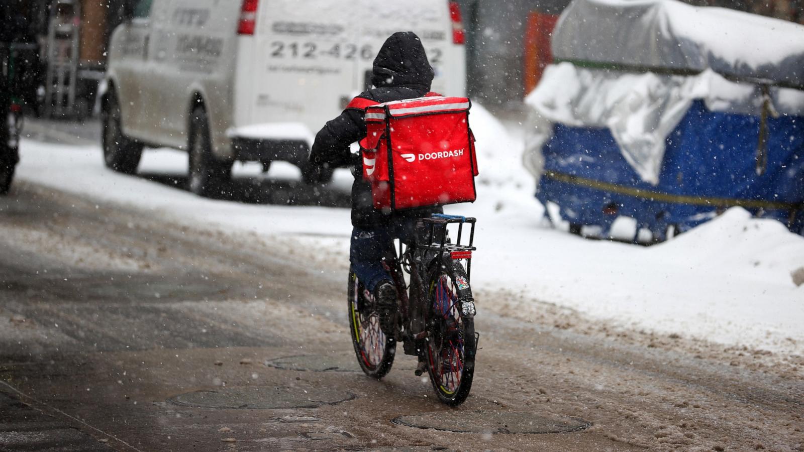 PHOTO: In this Feb. 18, 2021, file photo, a food delivery worker is seen as snowfall blankets the area in New York.